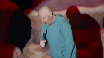 Movie still from “Bill Burr: Live at Red Rocks” (2022), directed by Mike Binder – A bald man holding a microphone in his hand; Medium shot, High angle