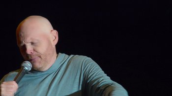 Movie still from “Bill Burr: Live at Red Rocks” (2022), directed by Mike Binder – A bald man with a shaved head is looking at the camera; Close Up shot, Low angle