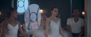 A woman in a white dress standing in front of a mirror