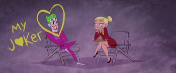 Two people sitting in chairs one of which has a heart in its mouth