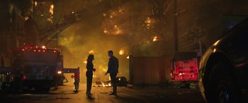 Movie still from “Birds of Prey” (2020), directed by Cathy Yan – Two people standing in front of a burning building; Wide shot, High angle