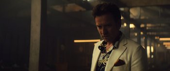 Movie still from “Birds of Prey” (2020), directed by Cathy Yan – A man in a white jacket is looking down; Close Up shot, Over the shoulder angle