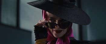 Movie still from “Birds of Prey” (2020), directed by Cathy Yan – A woman wearing a black hat and a pink head scarf; Close Up shot, Low angle