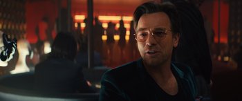 Movie still from “Birds of Prey” (2020), directed by Cathy Yan – A person wearing glasses and a black shirt; Close Up shot, Over the shoulder angle