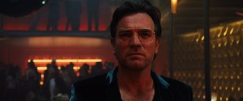 Movie still from “Birds of Prey” (2020), directed by Cathy Yan – A person wearing glasses and a jacket; Close Up shot, Low angle