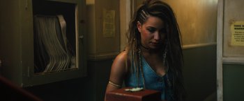 Movie still from “Birds of Prey” (2020), directed by Cathy Yan – A woman with dreads is looking at a red box; Close Up shot, Over the shoulder angle