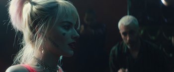 Movie still from “Birds of Prey” (2020), directed by Cathy Yan – A woman in a harley quinn costume looking to her left; Close Up shot, Over the shoulder angle