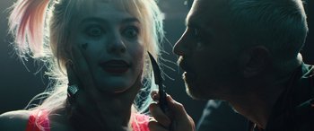 Movie still from “Birds of Prey” (2020), directed by Cathy Yan – A man cutting a woman's face with a large knife; Close Up shot, Over the shoulder angle