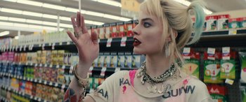 Movie still from “Birds of Prey” (2020), directed by Cathy Yan – A woman in a store holding a cigarette; Close Up shot, Over the shoulder angle