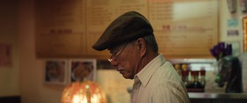 Movie still from “Birds of Prey” (2020), directed by Cathy Yan – An older man wearing glasses and a brown hat; Close Up shot, Low angle