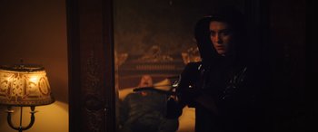 Movie still from “Birds of Prey” (2020), directed by Cathy Yan – A woman holding a gun in front of a man in a dark room; Medium shot, Over the shoulder angle