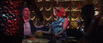 Movie still from “Birds of Prey” (2020), directed by Cathy Yan – A woman sitting at a table with a glass of wine; Medium shot, Low angle