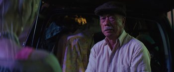 Movie still from “Birds of Prey” (2020), directed by Cathy Yan – An older man wearing a hat and a white shirt; Close Up shot, Over the shoulder angle