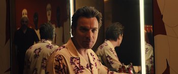 Movie still from “Birds of Prey” (2020), directed by Cathy Yan – A man in a floral shirt looking into a mirror; Close Up shot, Over the shoulder angle