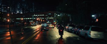 Movie still from “Birds of Prey” (2020), directed by Cathy Yan – A person riding a motorcycle down a street at night; Extreme Wide shot, High angle