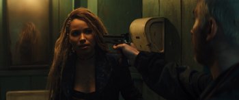 Movie still from “Birds of Prey” (2020), directed by Cathy Yan – A woman is holding a gun up to her face; Medium shot, Over the shoulder angle