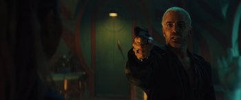 Movie still from “Birds of Prey” (2020), directed by Cathy Yan – A man holding a gun while standing in front of a door; Close Up shot, Low angle