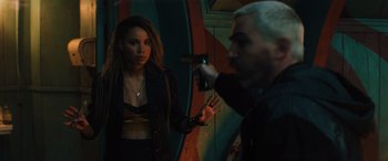 Movie still from “Birds of Prey” (2020), directed by Cathy Yan – A woman standing next to a man holding a gun; Medium shot, Over the shoulder angle