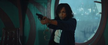 Movie still from “Birds of Prey” (2020), directed by Cathy Yan – A woman holding a handgun and a pair of handcuffs; Medium shot, Over the shoulder angle