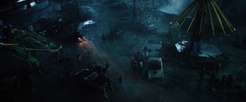 Movie still from “Birds of Prey” (2020), directed by Cathy Yan – A group of people standing in the middle of a parking lot at night; Extreme Wide shot, High angle