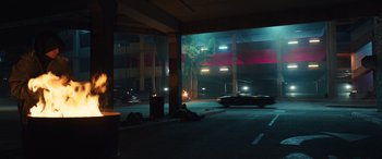 Movie still from “Birds of Prey” (2020), directed by Cathy Yan – A person laying on the ground in a parking lot; Extreme Wide shot, Low angle