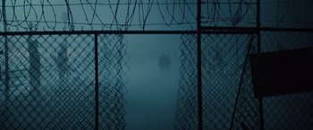 Movie still from “Birds of Prey” (2020), directed by Cathy Yan – A group of people walking through a fence in the fog; Extreme Wide shot, High angle