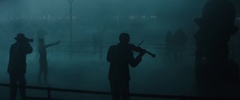 Movie still from “Birds of Prey” (2020), directed by Cathy Yan – A man is playing a violin in the fog; Extreme Wide shot, Low angle
