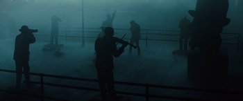 Movie still from “Birds of Prey” (2020), directed by Cathy Yan – A man playing a violin in the middle of a foggy night; Extreme Wide shot, Low angle