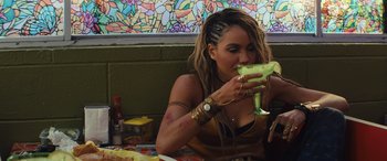 Movie still from “Birds of Prey” (2020), directed by Cathy Yan – A woman sitting at a table eating a piece of food; Close Up shot, Over the shoulder angle