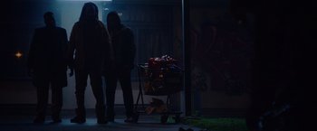 Movie still from “Black as Night” (2021), directed by Maritte Lee Go – Two people standing next to a shopping cart; Wide shot, Low angle