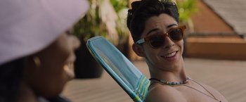 Movie still from “Black as Night” (2021), directed by Maritte Lee Go – A young man wearing sunglasses and holding an umbrella; Close Up shot, Over the shoulder angle