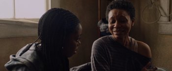 Movie still from “Black as Night” (2021), directed by Maritte Lee Go – Two women sitting next to each other on a bed; Close Up shot, Over the shoulder angle