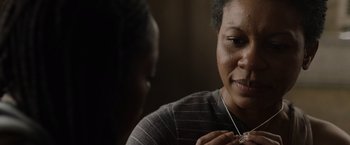 Movie still from “Black as Night” (2021), directed by Maritte Lee Go – Two women are talking and one of them is holding a necklace; Close Up shot, Over the shoulder angle