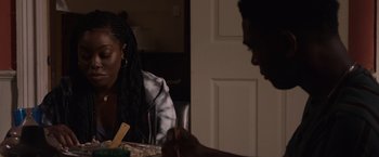 Movie still from “Black as Night” (2021), directed by Maritte Lee Go – Two people sitting at a dinner table eating food; Close Up shot, Over the shoulder angle