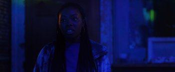 Movie still from “Black as Night” (2021), directed by Maritte Lee Go – A woman with long black hair standing in the dark; Close Up shot, Over the shoulder angle