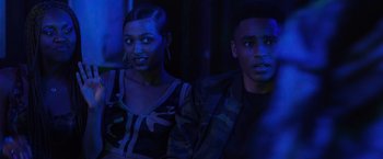 Movie still from “Black as Night” (2021), directed by Maritte Lee Go – A man and a woman sitting next to each other in the dark; Medium shot, Over the shoulder angle