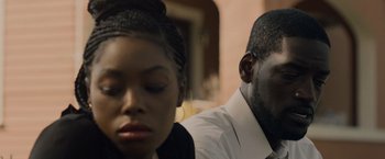 Movie still from “Black as Night” (2021), directed by Maritte Lee Go – A man and a woman sitting next to each other; Close Up shot, Over the shoulder angle