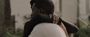 Movie still from “Black as Night” (2021), directed by Maritte Lee Go – Two people hugging each other in a room; Close Up shot, Over the shoulder angle