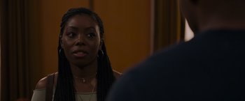 Movie still from “Black as Night” (2021), directed by Maritte Lee Go – A woman with long braids sitting in front of a man; Close Up shot, Over the shoulder angle