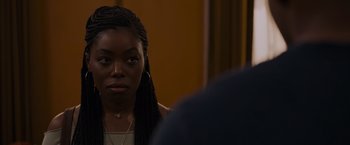 Movie still from “Black as Night” (2021), directed by Maritte Lee Go – A woman with braids looking at a man in a suit; Close Up shot, Over the shoulder angle