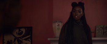 Movie still from “Black as Night” (2021), directed by Maritte Lee Go – A woman standing in front of a red wall; Close Up shot, Over the shoulder angle