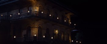 Movie still from “Black as Night” (2021), directed by Maritte Lee Go – A building lit up at night with lights on; Extreme Wide shot, Low angle