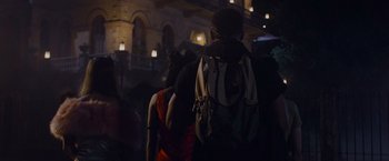 Movie still from “Black as Night” (2021), directed by Maritte Lee Go – A couple of people with backpacks walking in the dark; Medium shot, Over the shoulder angle
