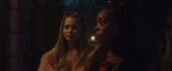 Movie still from “Black as Night” (2021), directed by Maritte Lee Go – Two young women standing next to each other in a dark room; Close Up shot, Over the shoulder angle