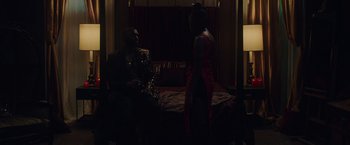 Movie still from “Black as Night” (2021), directed by Maritte Lee Go – A man and a woman are sitting on a bed in the dark; Medium shot, Over the shoulder angle