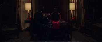 Movie still from “Black as Night” (2021), directed by Maritte Lee Go – A man and a woman sitting on a bed in the dark; Medium shot, High angle
