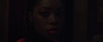 Movie still from “Black as Night” (2021), directed by Maritte Lee Go – A woman's face in the dark; Close Up shot, Low angle