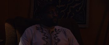 Movie still from “Black as Night” (2021), directed by Maritte Lee Go – A man sitting in a chair looking up at the ceiling; Close Up shot, Over the shoulder angle