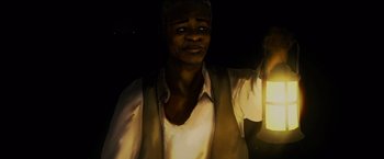 Movie still from “Black as Night” (2021), directed by Maritte Lee Go – A man holding a lantern while standing in the dark; Close Up shot, High angle