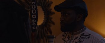 Movie still from “Black as Night” (2021), directed by Maritte Lee Go – A person wearing a hat; Close Up shot, Over the shoulder angle